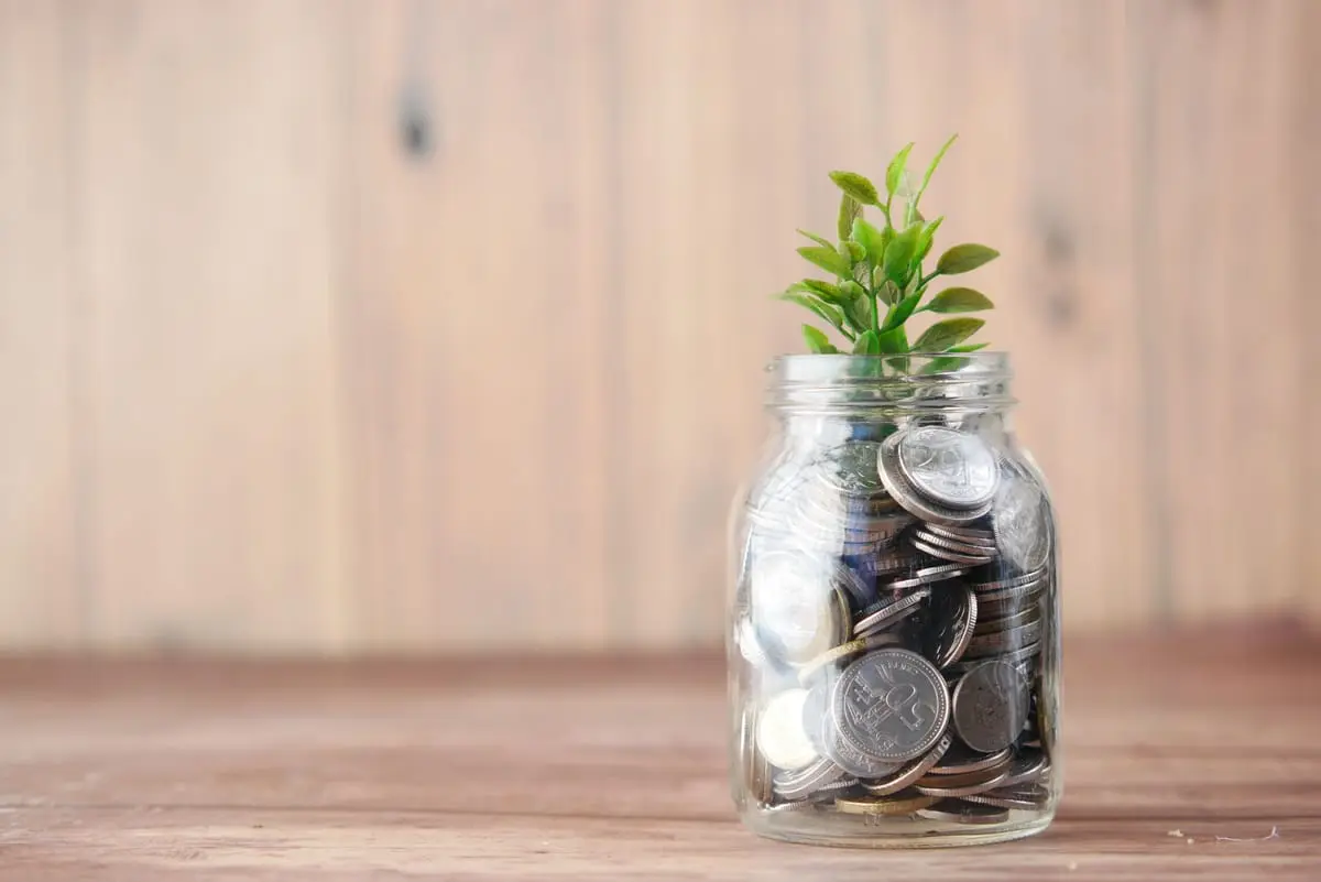 Ahorro voluntario en frasco de monedas para comprar casa