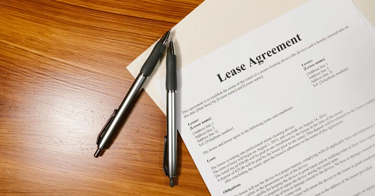 Contrato de arrendamiento y calculadora revisando el aumento de renta